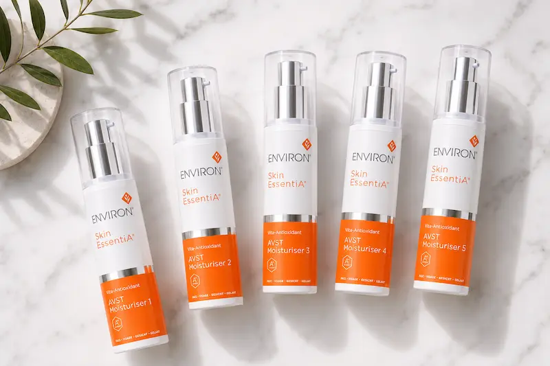 Environ AVST Moisturiser 1 through 5 arranged in progression on white marble surface showing vitamin A step-up system for rosacea sensitive skin